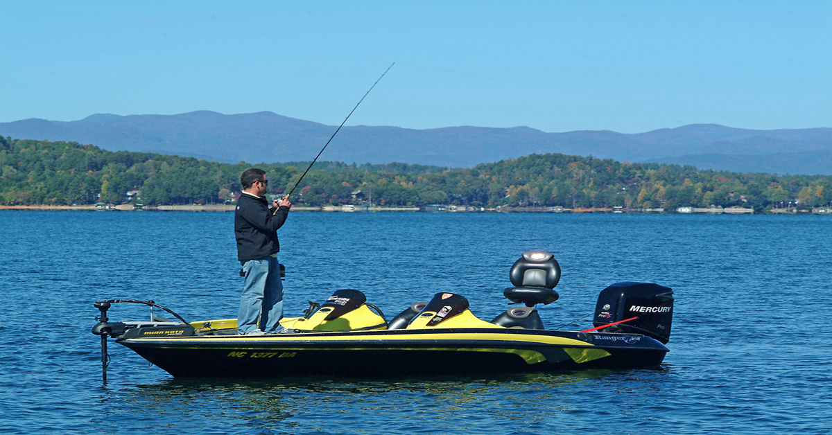 man fishing from boat on lake keowee