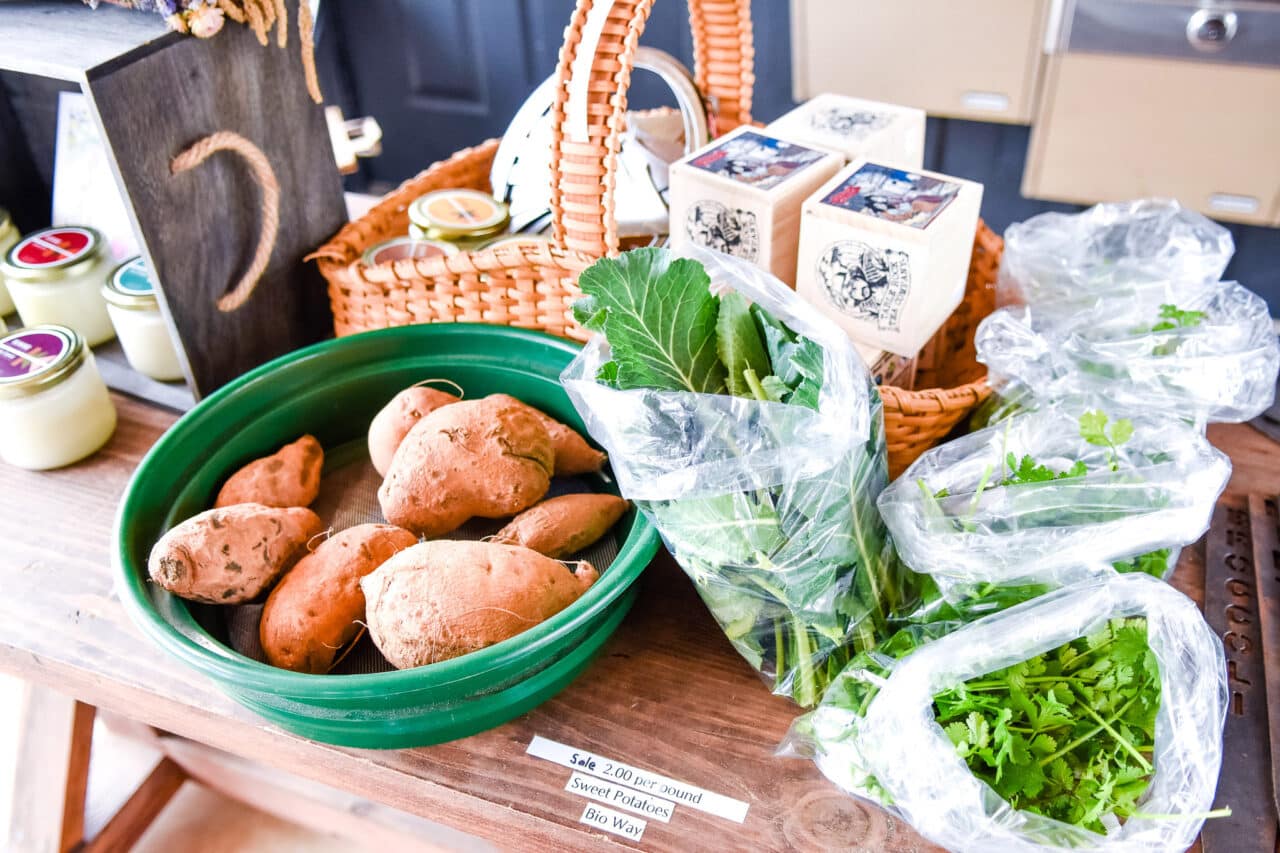 a table with fresh vegetables and products from a farmer's market. 